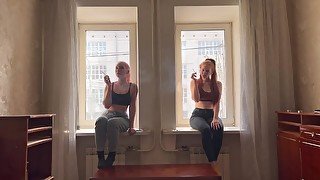 Two girls are smoking on the window