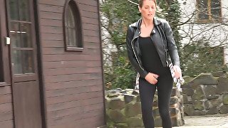 Lewd shameless brunette in black jacket pisses outdoors on the street