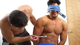 Handsome gay guy puts on a blindfold while getting tickled by a friend