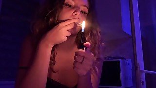 Curly haired girl smokes a late night cigarette and touches her body!