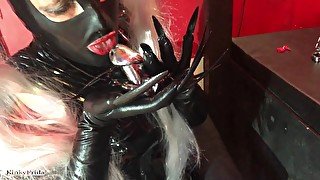 Kinky latex Girl with piercings and extremely long nails shows off her collection of chastity cages.