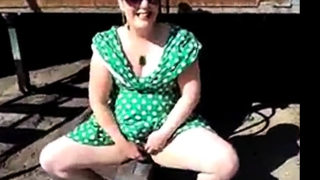 Flashing in green dress and white stilettos