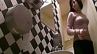 Busty brunette white woman in the ladies room pisses