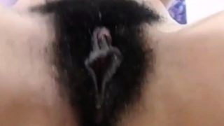 Curly brunette fingering her hairy pussy at bathroom