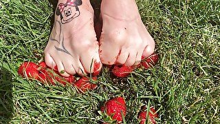 Feet crushing strawberries close up