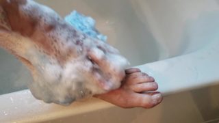 Jolie jeune fille dans la douche se savonne et se caresse