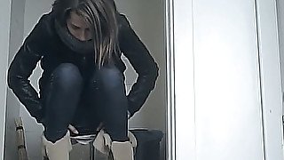 White young chick in leather jacket and jeans filmed in the toilet