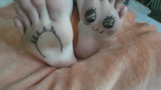 Kawaii japanese girl plays with her painted pale feet