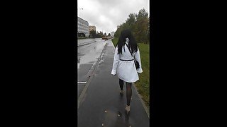 Sissy walks on the street in a new coat