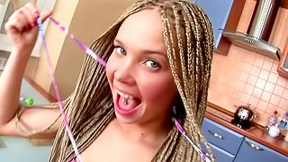 Teen wearing braids masturbates with a fruit in the kitchen