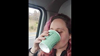 girlfriend drinks a big cup of very yellow piss in car.