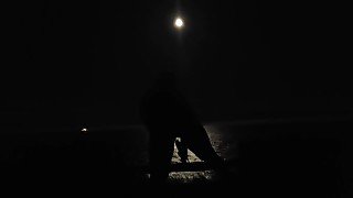 Woman dildo fucks pussy in moonlight by the ocean