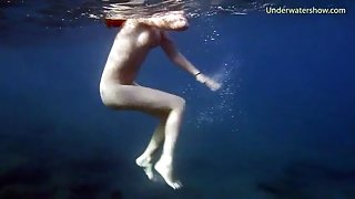 Naked redheaded beauty swims in the ocean