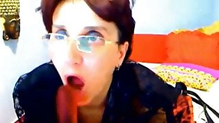 Four eyed mature whore is sucking her big dildo like a woman possessed