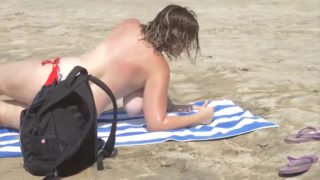 Busty milf on beach showing big tits