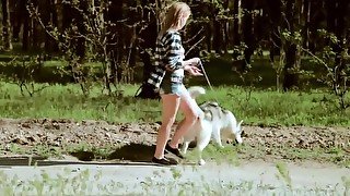 Beautiful college girl takes a walk with the dog