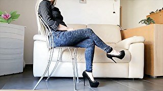 Toe tapping crossed legs: high heels and blue jeans