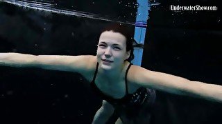 Beautiful girl swims and smiles underwater