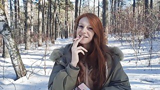 redhead smokes in the forest