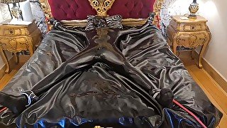 Latex-encased Woman Tied To Bed