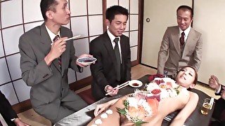 More men eat food from a Japanese girl and stick toys inside her hairy pussy