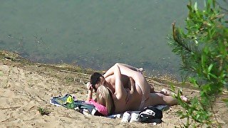 A couple of young nudists are spied on while having sex and enjoying themselves on the beach