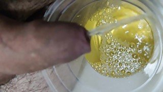 Relaxing piss into clear cup