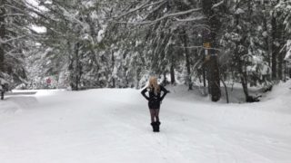 Sexy female mask, short dress, legs and boots out in the snow.