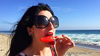 Luscious Lopez licks popsicle on beach