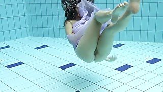 Floating virgin babe swims and strips underwater