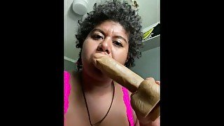 Sucking on a huge dildo