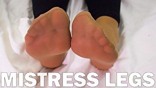 Foot fetish Goddess feet in soft nylon socks is resting on the bed