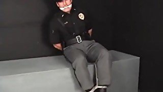 Handsome young policeman cuffed gagged and struggling.