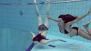 Two naughty babes undress under the water and does tricks