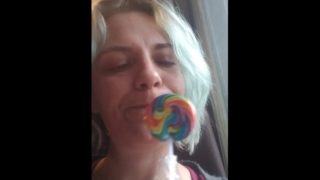 Blue haired girl licks and sucks lollipop