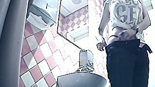 Brunette young cutie in black pants shows her ass and pisses in the toilet