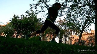 Doing lunges in a public park at sunset, voyeur clip from the grass