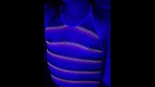 Asian Trans plays in blacklight rainbow