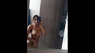 Beautiful brunette records herself in front of her mirror while masturbating