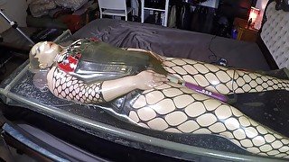 Miss Maskerade in latex vacuum bed wearing a silicone female mask as a rubber doll