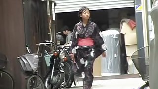 Cute Asian in a jukata has boob sharking on the street.