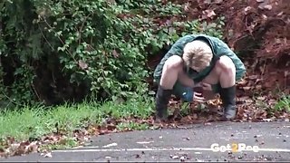 Short hair blonde in a parking lot goes pee