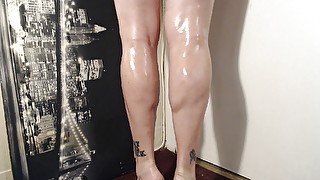 Oiled calves flexing calve muscle