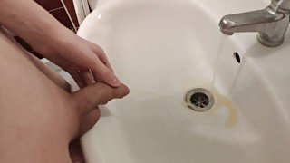 Gay with a shaved cock pissing in the sink