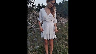 Lovely girl in a white dress pissing outdoors