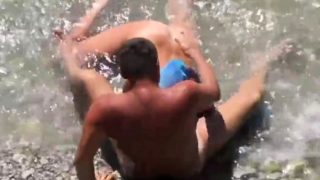 Girl sucks dick her boyfriend in the surf at a public beach