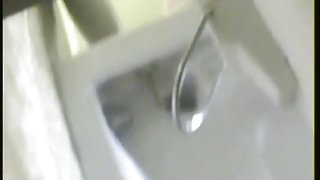 A bikini wearing girl is pissing in beach toilet