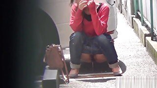 Asian whore pees behind car