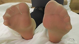 Mistress Feet In Soft Nylon Socks Is Resting On The Bed