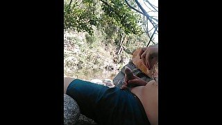 Boy playing with himself in a condom near a river